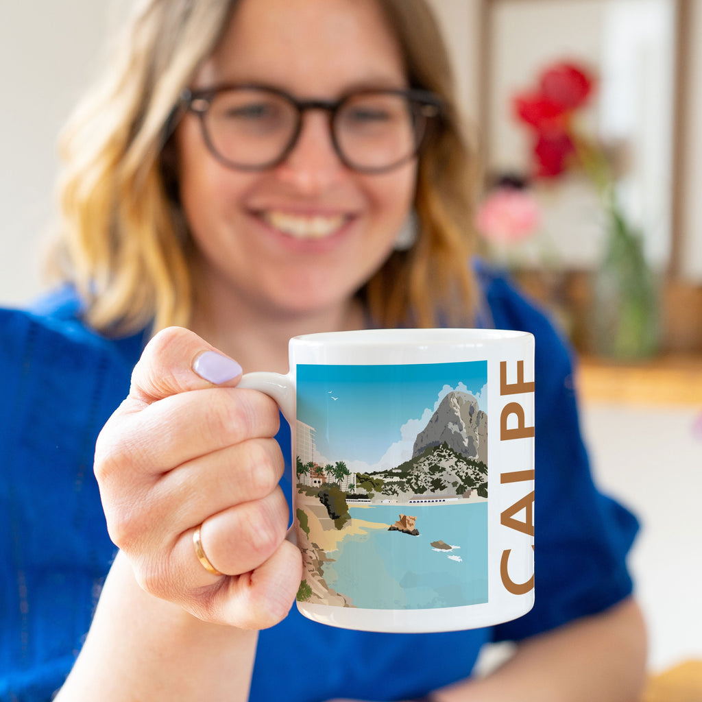 a woman in a blue shirt holding a coffee mug