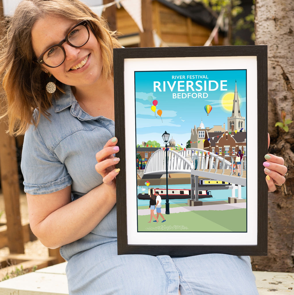 a woman holding up a picture of a bridge