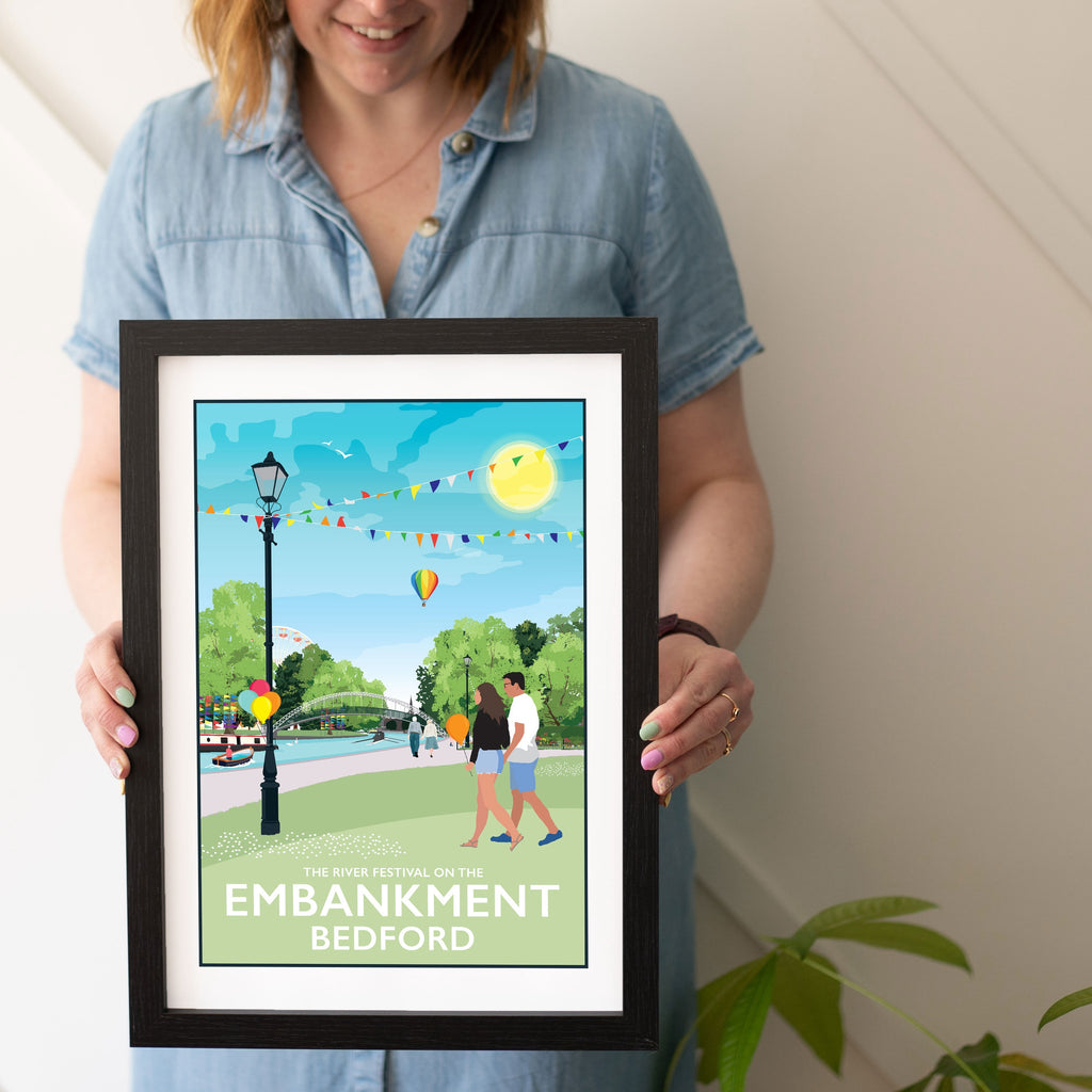 a woman holding a framed poster of a park